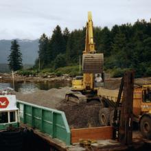 Material barge with excavator unloading aggregate 