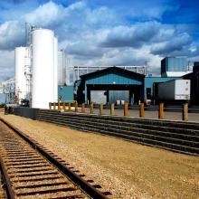 Railway Tracks in front of chemical storage tanks and truck canopy