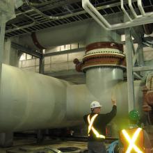 NAC employees next to large piping