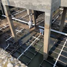 Empty aeriation Tank with NAC workers installing process equipment and pipe