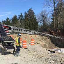 concrete pump truck arm pouring into deep excavation