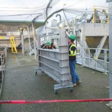 Installers moving Slide Gates for tank
