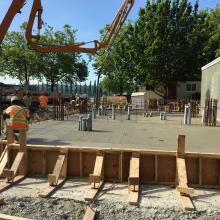 Pump truck next to formwork for building addition slab pour