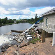Hilltop view of crane in between the falls and the Bracebridge Falls Generating Station